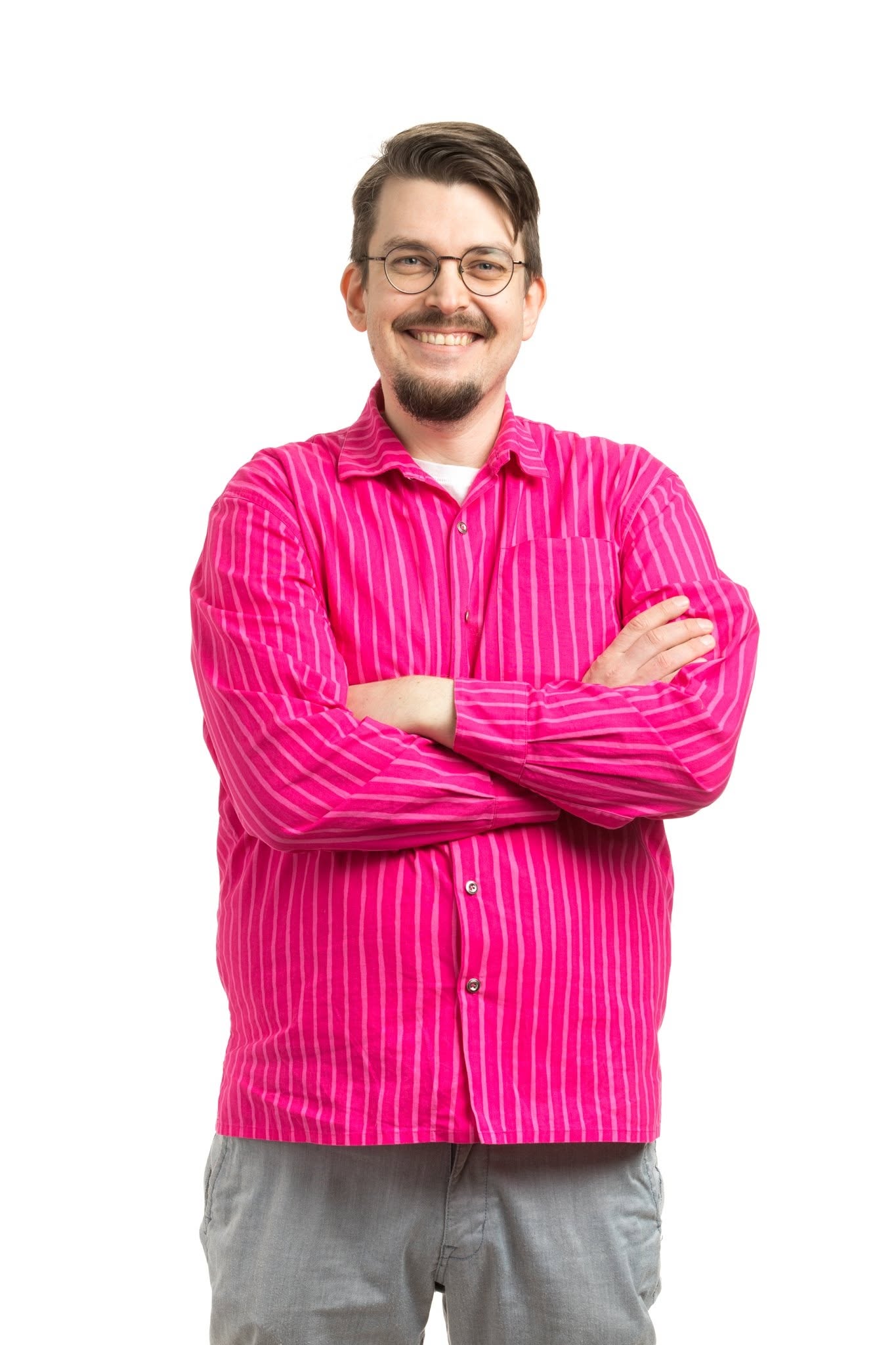 Aarne Halen smiling, wearing a pink striped shirt with his arms crossed
